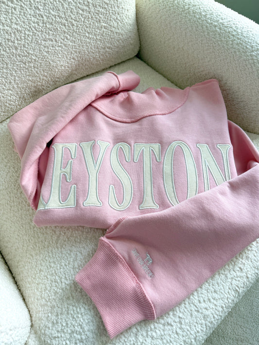 Pink sweatshirt with 'Keystone' text on a light background