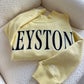 Yellow sweatshirt with 'KEYSTONE' text on a white surface